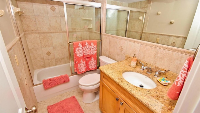 full bathroom with enclosed tub / shower combo, tile patterned flooring, vanity, tile walls, and toilet