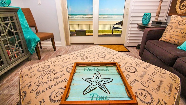 sitting room with a water view and hardwood / wood-style floors