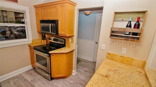 kitchen featuring stainless steel appliances and light stone counters