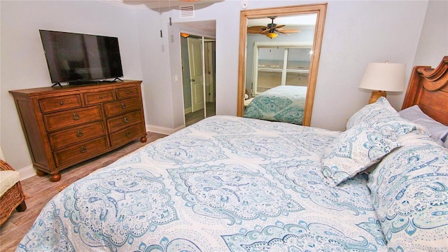 bedroom featuring ceiling fan, a closet, and light wood-type flooring