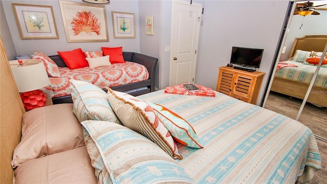 bedroom featuring ceiling fan, a closet, and hardwood / wood-style flooring