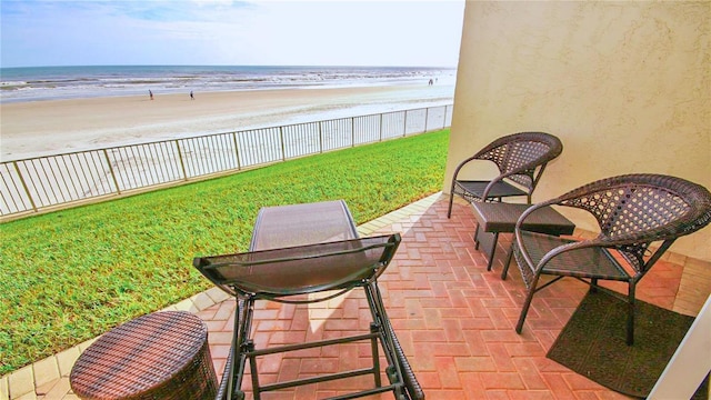 view of patio with a water view and a view of the beach