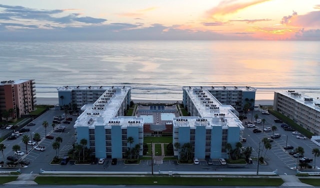 aerial view at dusk featuring a water view