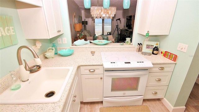 kitchen with light wood-type flooring, white cabinetry, electric range, and sink