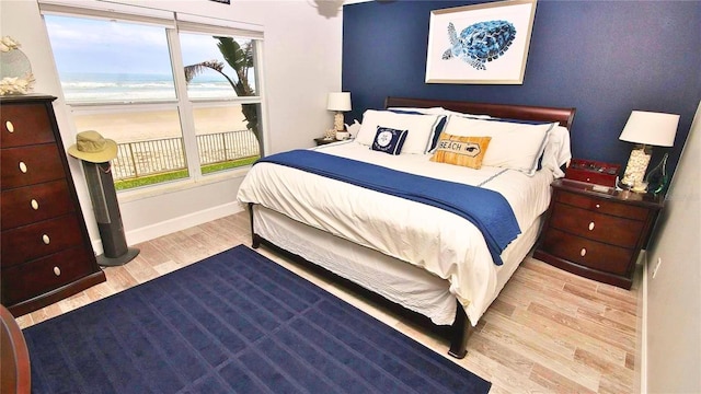 bedroom featuring a water view and light hardwood / wood-style flooring