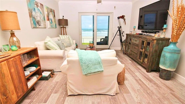 living area with crown molding and light hardwood / wood-style flooring