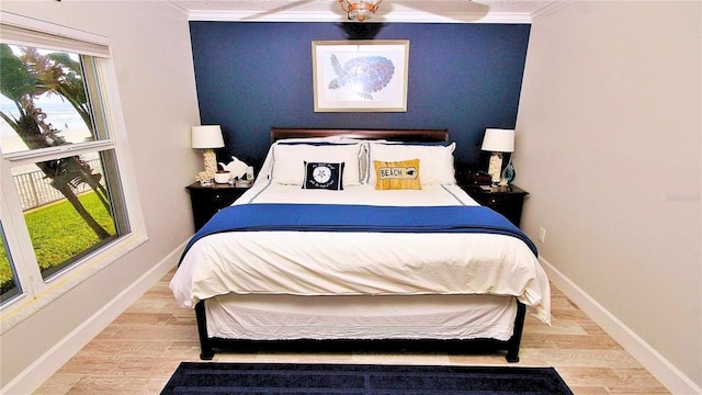 bedroom with ceiling fan, ornamental molding, and light wood-type flooring