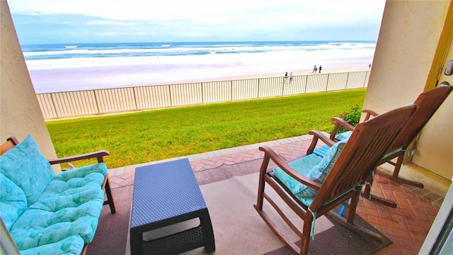 view of patio / terrace featuring a beach view and a water view