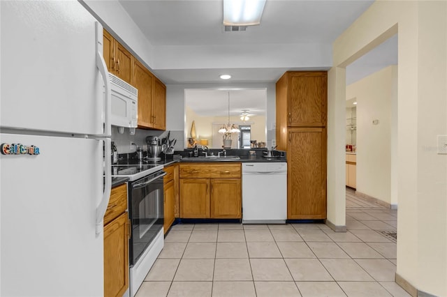 kitchen featuring an inviting chandelier, light tile patterned flooring, sink, and white appliances