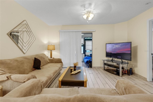 living room with ceiling fan and a textured ceiling