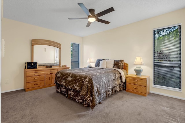 carpeted bedroom featuring ceiling fan and multiple windows