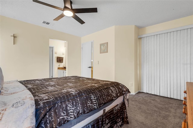 bedroom with ceiling fan, a textured ceiling, ensuite bath, and carpet flooring