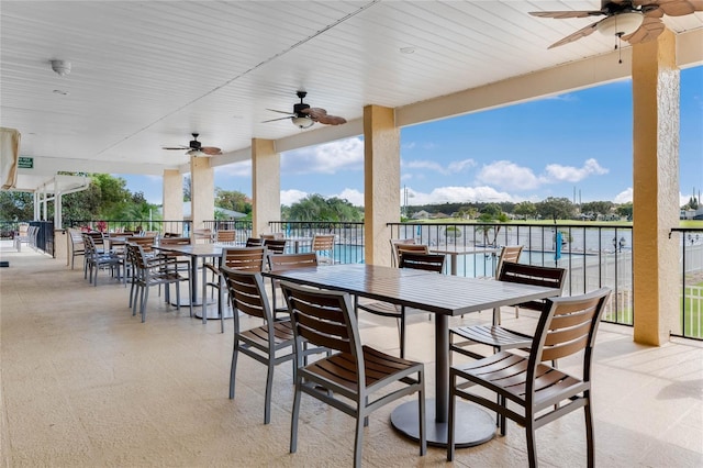 view of patio / terrace with ceiling fan and a water view