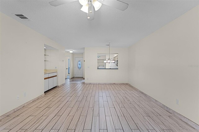 2923 Marshfield Ct Unit Ge, Orlando, FL 32822 - unfurnished living room featuring light wood-style flooring, a ceiling fan, a chandelier, a textured ceiling, and baseboards