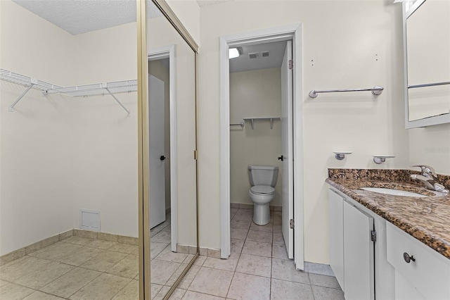 2923 Marshfield Ct Unit Ge, Orlando, FL 32822 - bathroom featuring vanity, toilet, a walk in closet, and tile patterned flooring