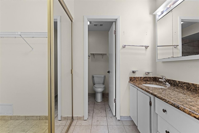2923 Marshfield Ct Unit Ge, Orlando, FL 32822 - bathroom with vanity, a walk in closet, toilet, tile patterned flooring, and baseboards
