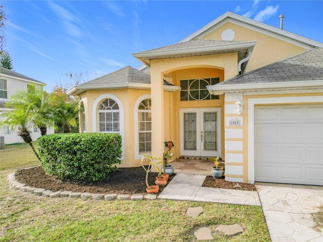 view of exterior entry featuring french doors and a garage