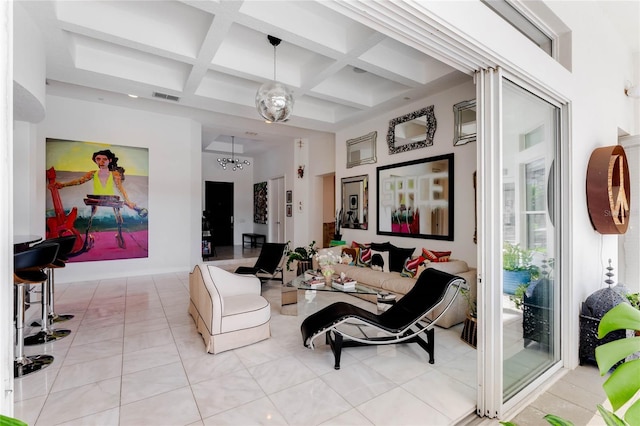 living room with light tile patterned flooring, beam ceiling, a notable chandelier, and coffered ceiling