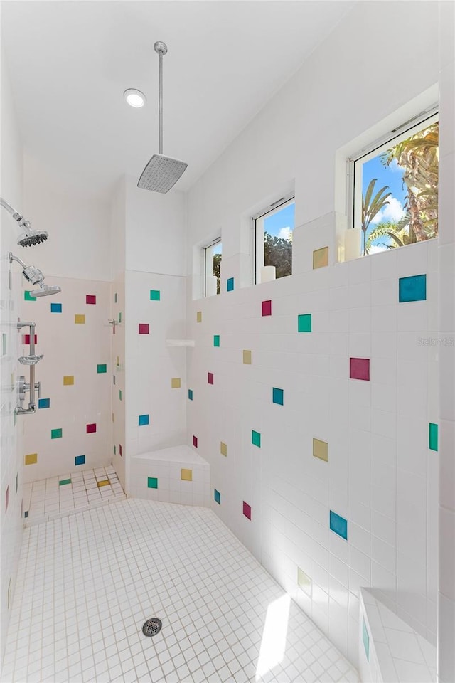 bathroom with a tile shower and tile walls