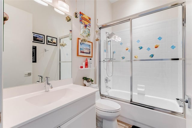 full bathroom featuring bath / shower combo with glass door, toilet, and vanity