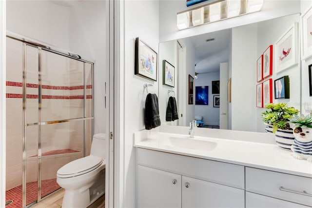 bathroom with toilet, vanity, and an enclosed shower