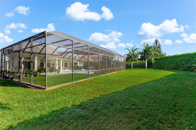 view of yard with glass enclosure and a patio