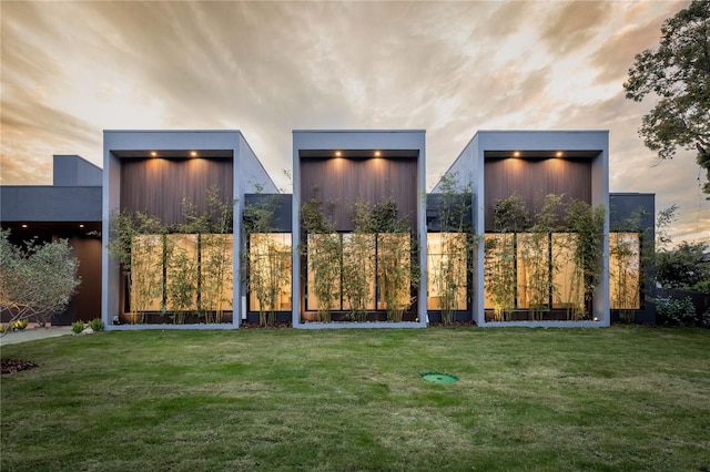 gate at dusk featuring a lawn