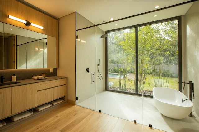 bathroom with vanity, hardwood / wood-style flooring, and shower with separate bathtub