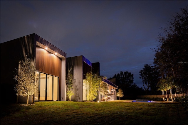 property exterior at twilight with a yard