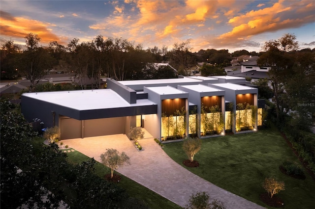 modern home featuring a garage and a yard