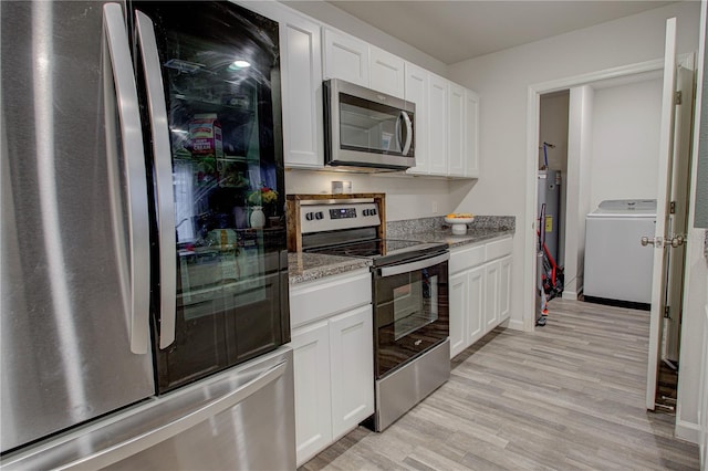 kitchen featuring stainless steel appliances, washer / dryer, white cabinets, and light stone counters