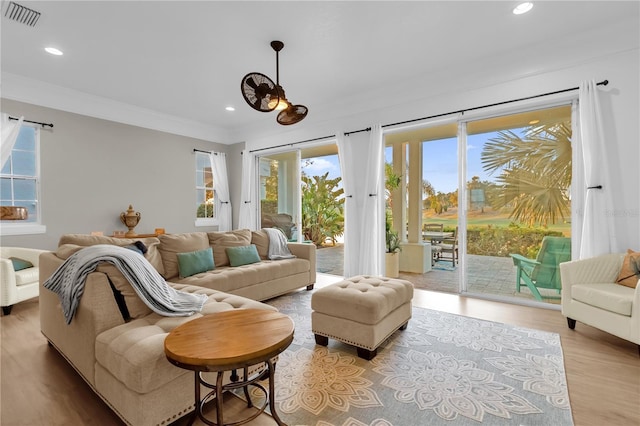 living room featuring ornamental molding and light hardwood / wood-style floors