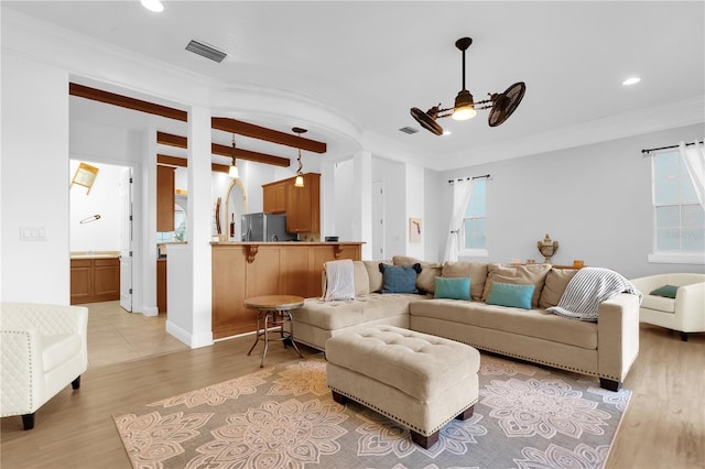 living room featuring ornamental molding, light wood-type flooring, and ceiling fan