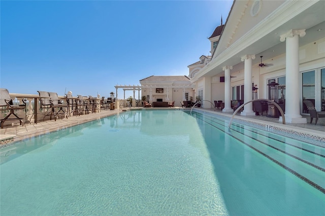 view of swimming pool featuring ceiling fan and a pergola