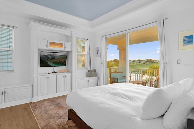 bedroom featuring access to exterior, hardwood / wood-style flooring, and ornamental molding