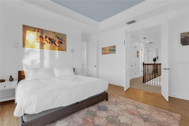 bedroom featuring crown molding and wood-type flooring