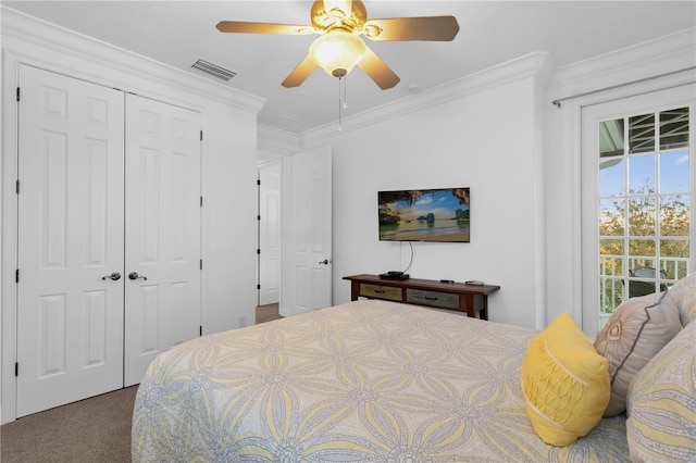 bedroom featuring crown molding, ceiling fan, carpet flooring, and a closet