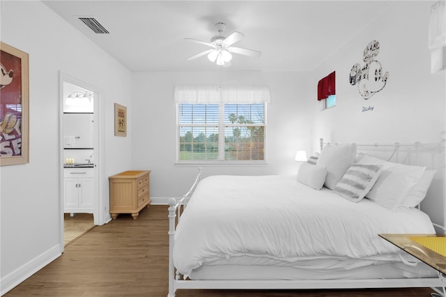 bedroom featuring dark hardwood / wood-style flooring, ceiling fan, and ensuite bathroom