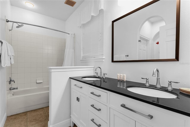 bathroom featuring tile patterned flooring, vanity, and shower / tub combo