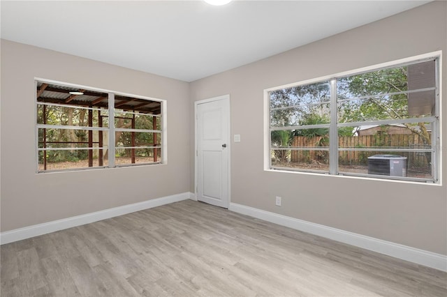 spare room with a wealth of natural light and light hardwood / wood-style floors