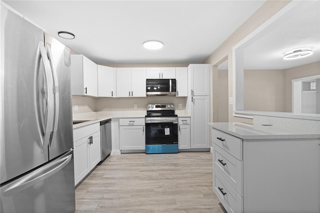 kitchen featuring white cabinetry, stainless steel appliances, and light wood-type flooring