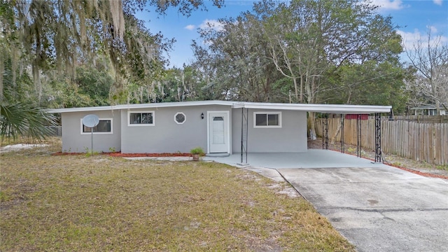 ranch-style home featuring a carport and a front yard