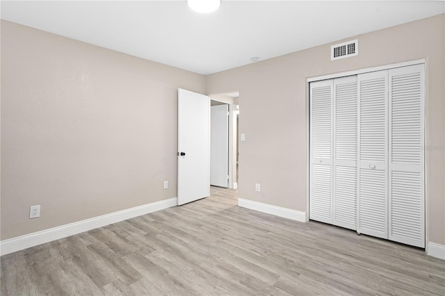 unfurnished bedroom with light hardwood / wood-style floors and a closet