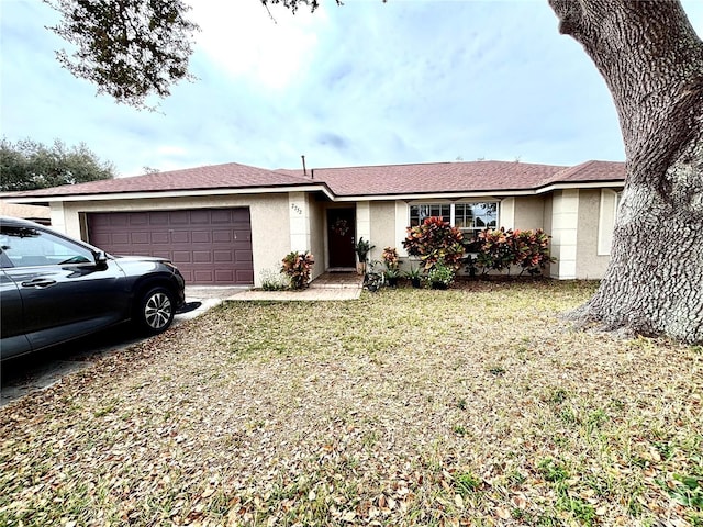 ranch-style house featuring a garage and a front lawn