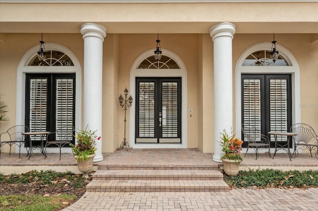 entrance to property with covered porch and french doors