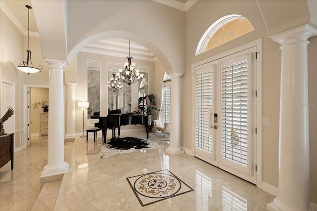 foyer entrance featuring a wealth of natural light, a chandelier, and crown molding