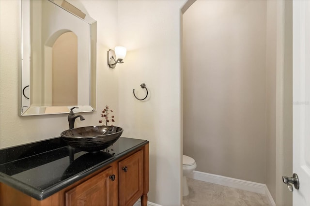 bathroom with toilet, tile patterned floors, and vanity