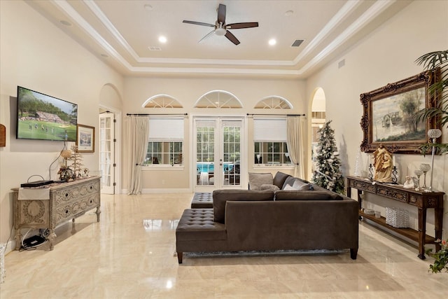 living room featuring a high ceiling, ceiling fan, a raised ceiling, and french doors