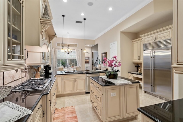 kitchen featuring a kitchen island, sink, an inviting chandelier, hanging light fixtures, and stainless steel appliances