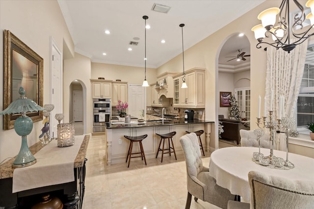 dining area featuring ceiling fan with notable chandelier and sink